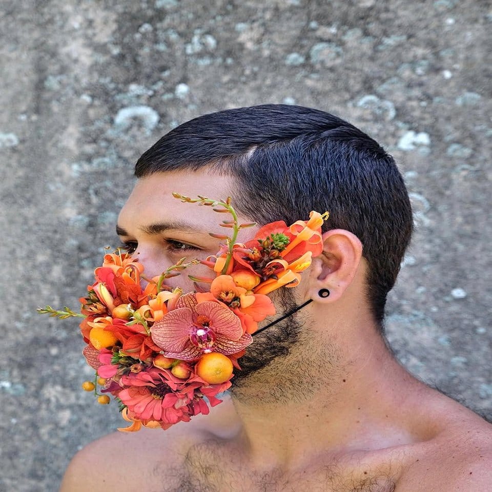 Feathered carnival mask alongside blooming orchid arrangement