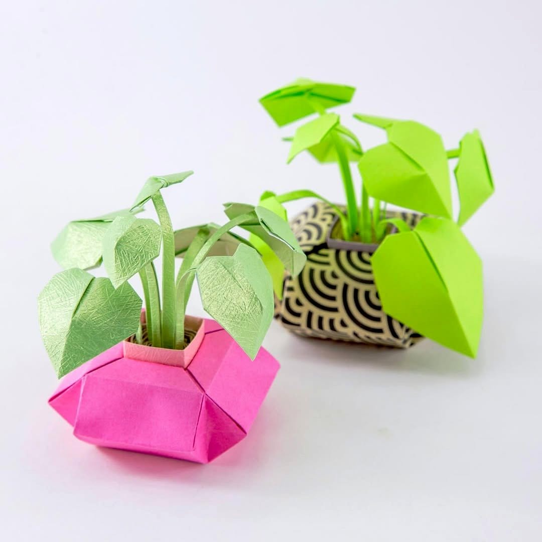 Miniature origami cranes holding small pots