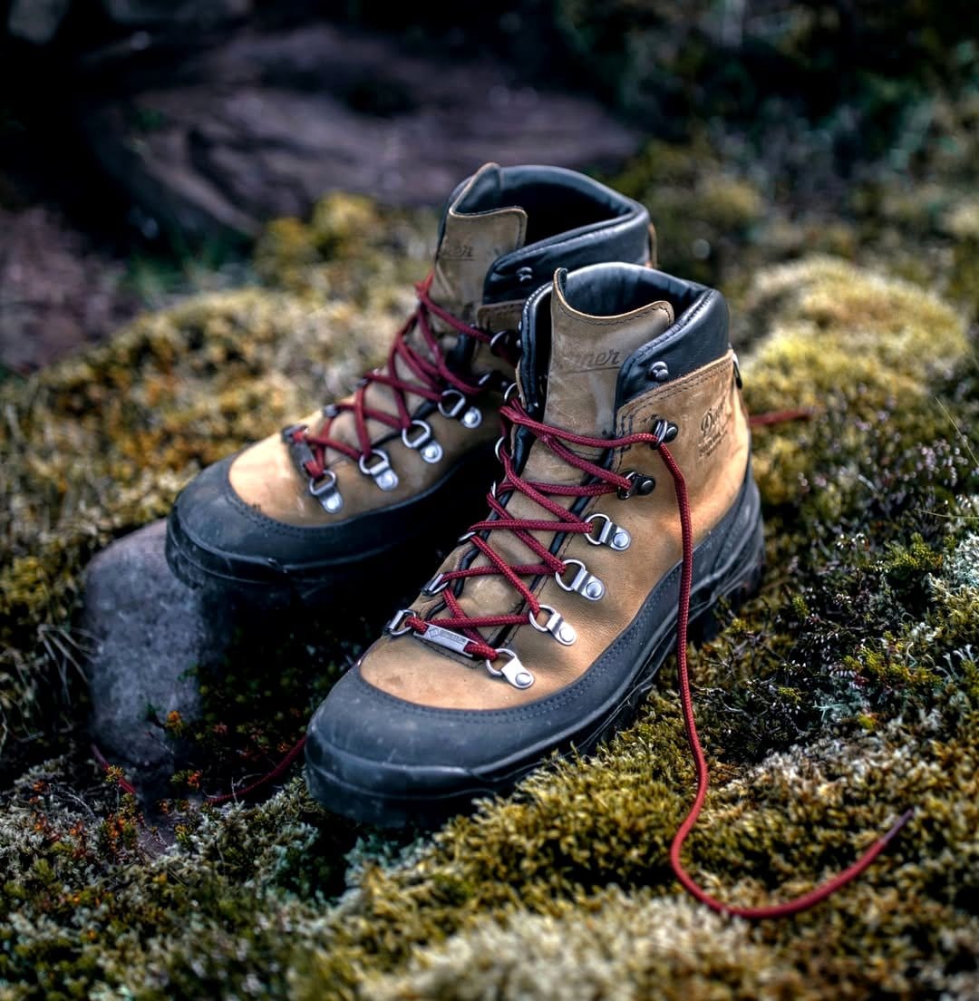 weathered hiking boots with wildflowers