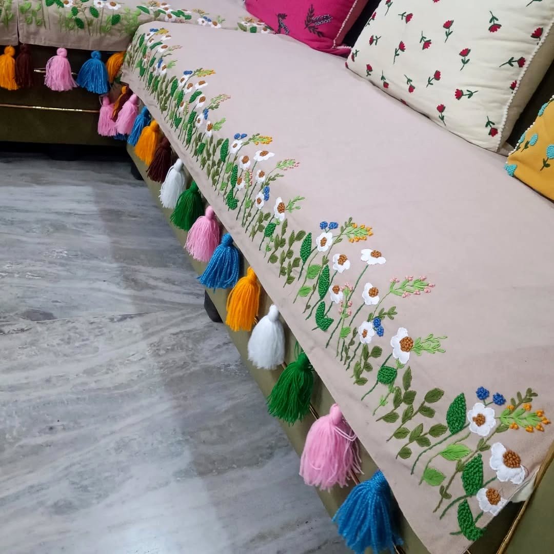 Linen-covered cushions on a sofa with nearby potted plants