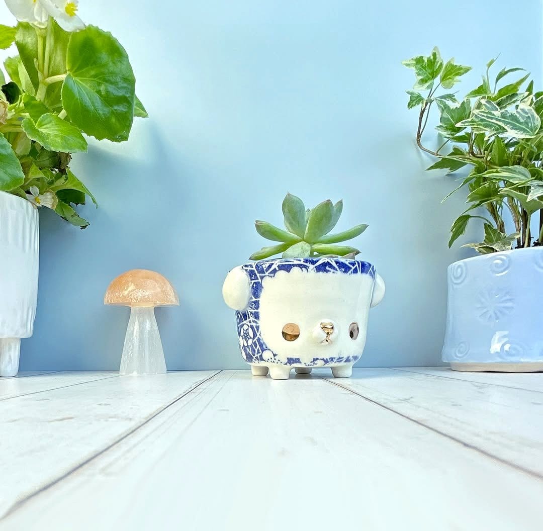 Delicate porcelain figurines with potted plants