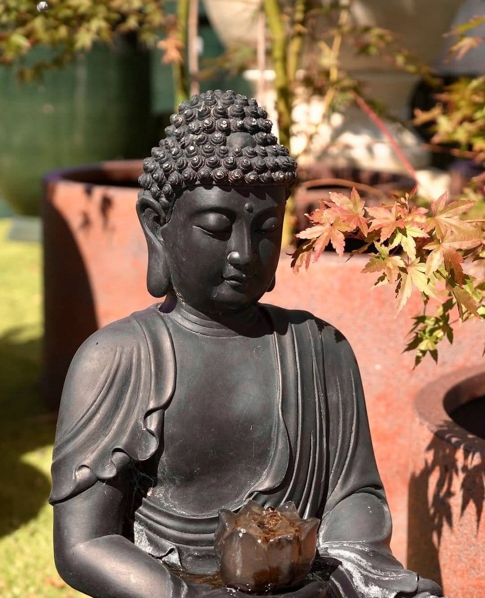small Buddha statue among plants