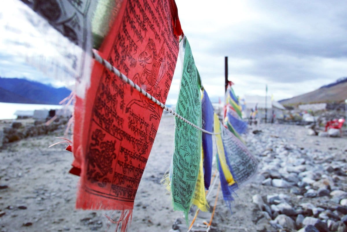 Peaceful bedroom with hanging prayer flags and plants
