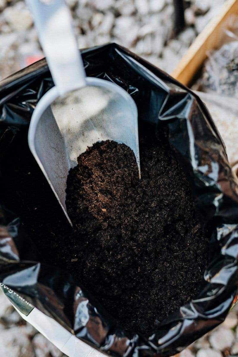 gardener mixing compost into soil