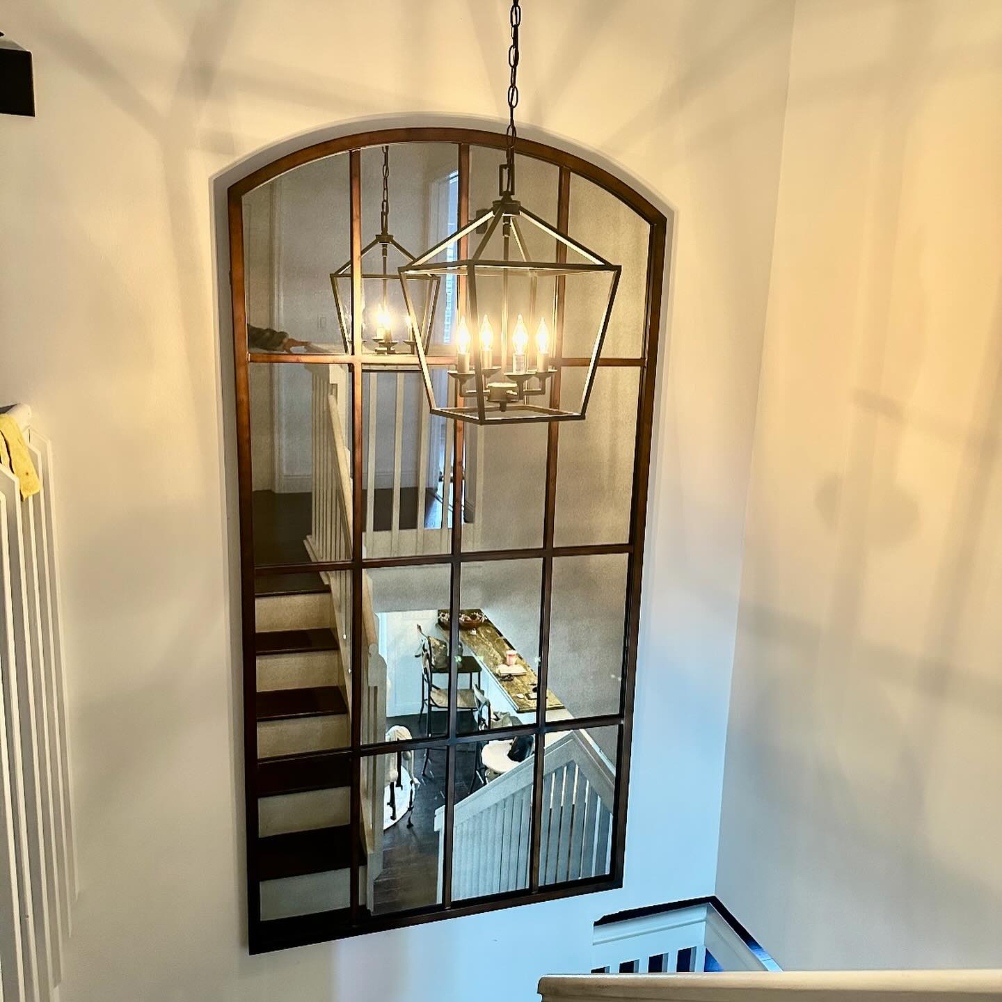 staircase with mirror and plant accents