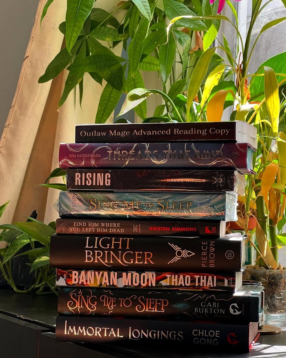 stack of books under plant