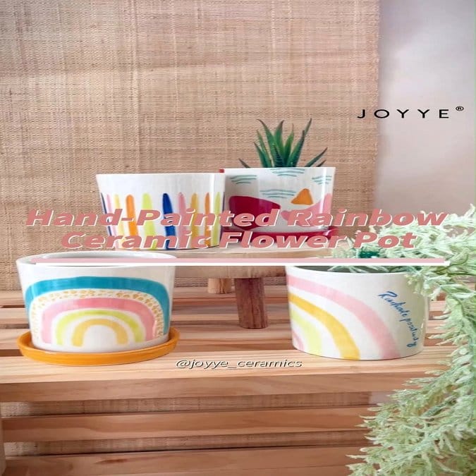 Rainbow-colored plant pots on a white shelf