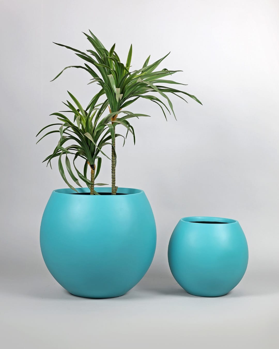 bright red fiberglass planter in garden