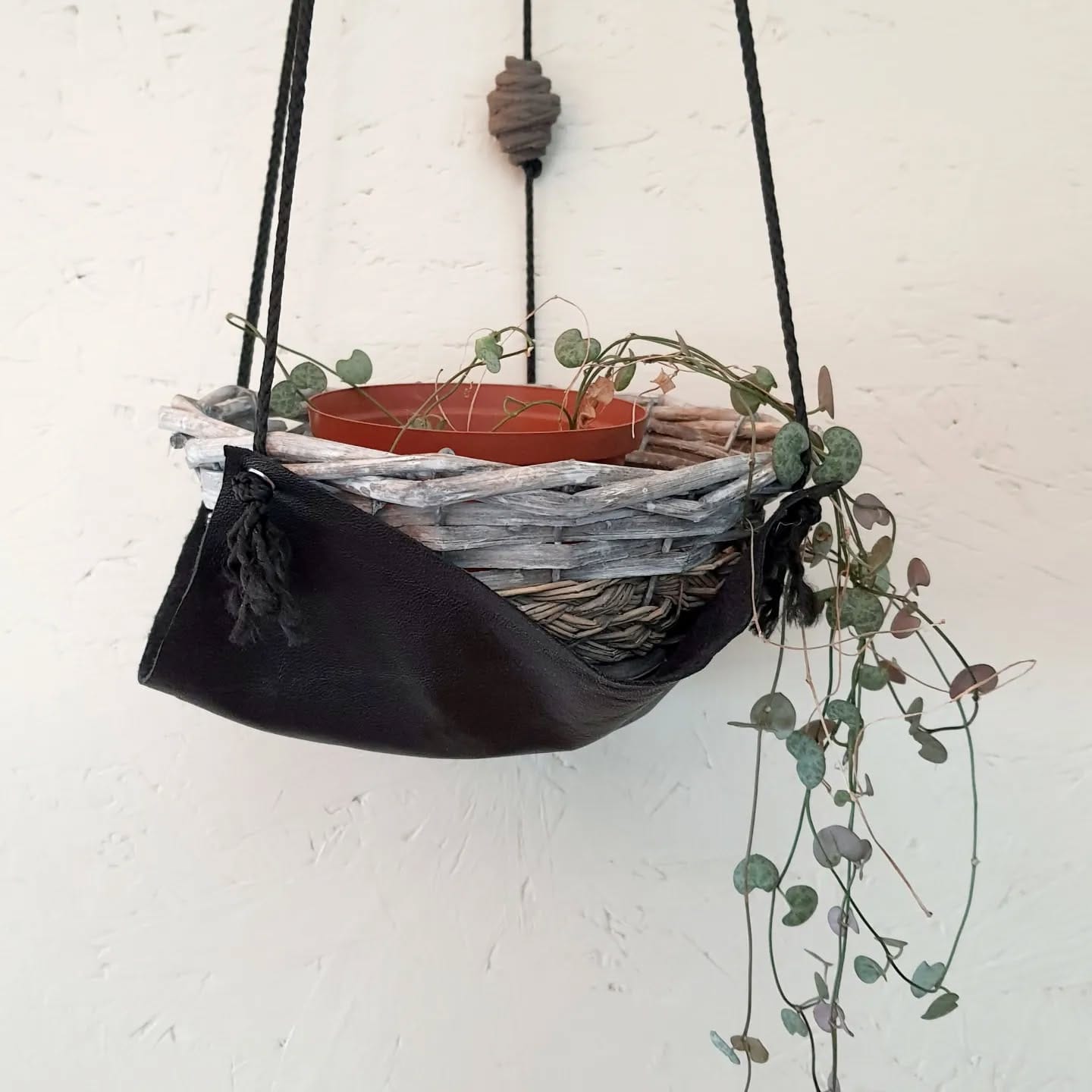 geometric patterned leather plant sleeve on geometric shelf