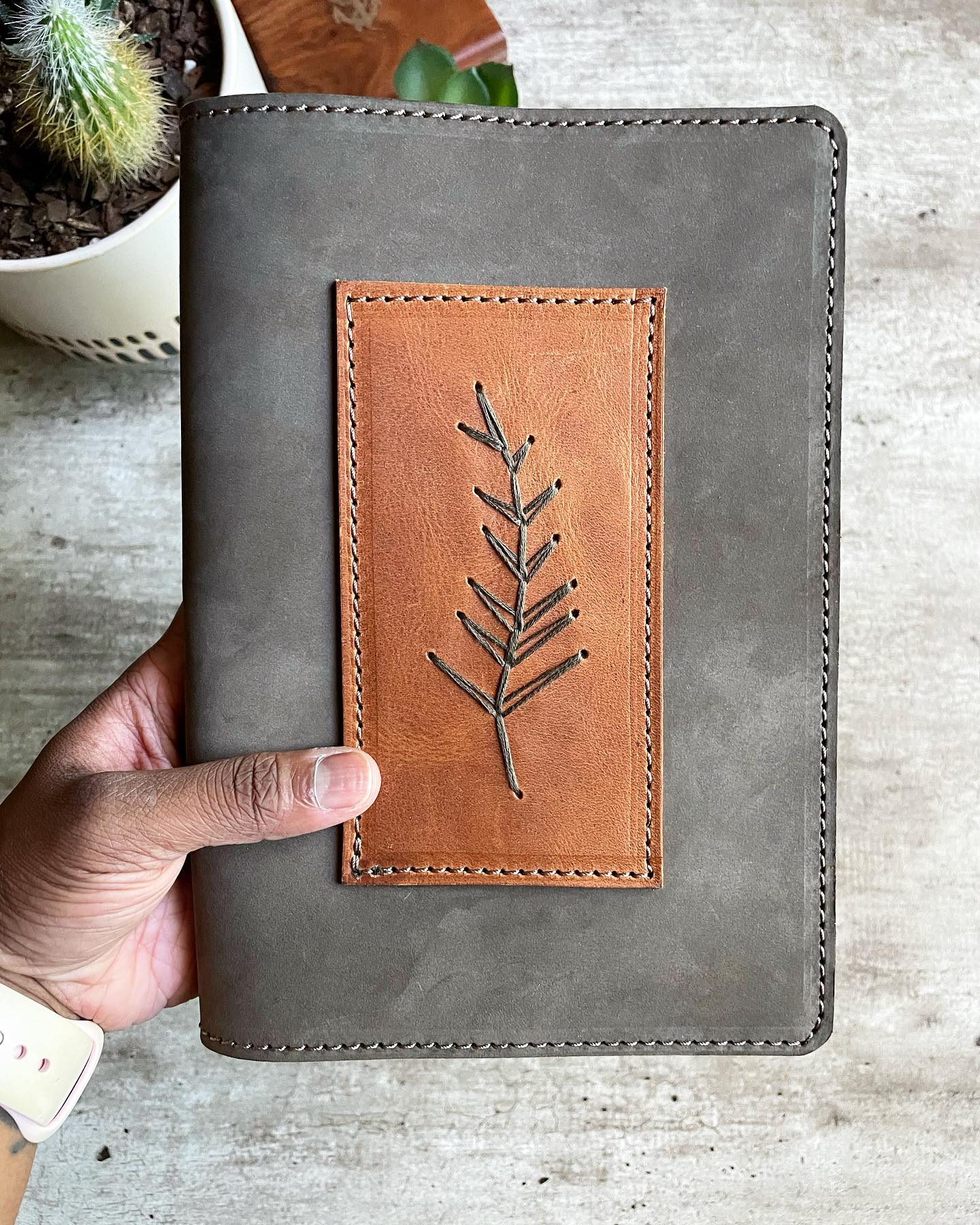 metallic-accented leather plant sleeve on glass table