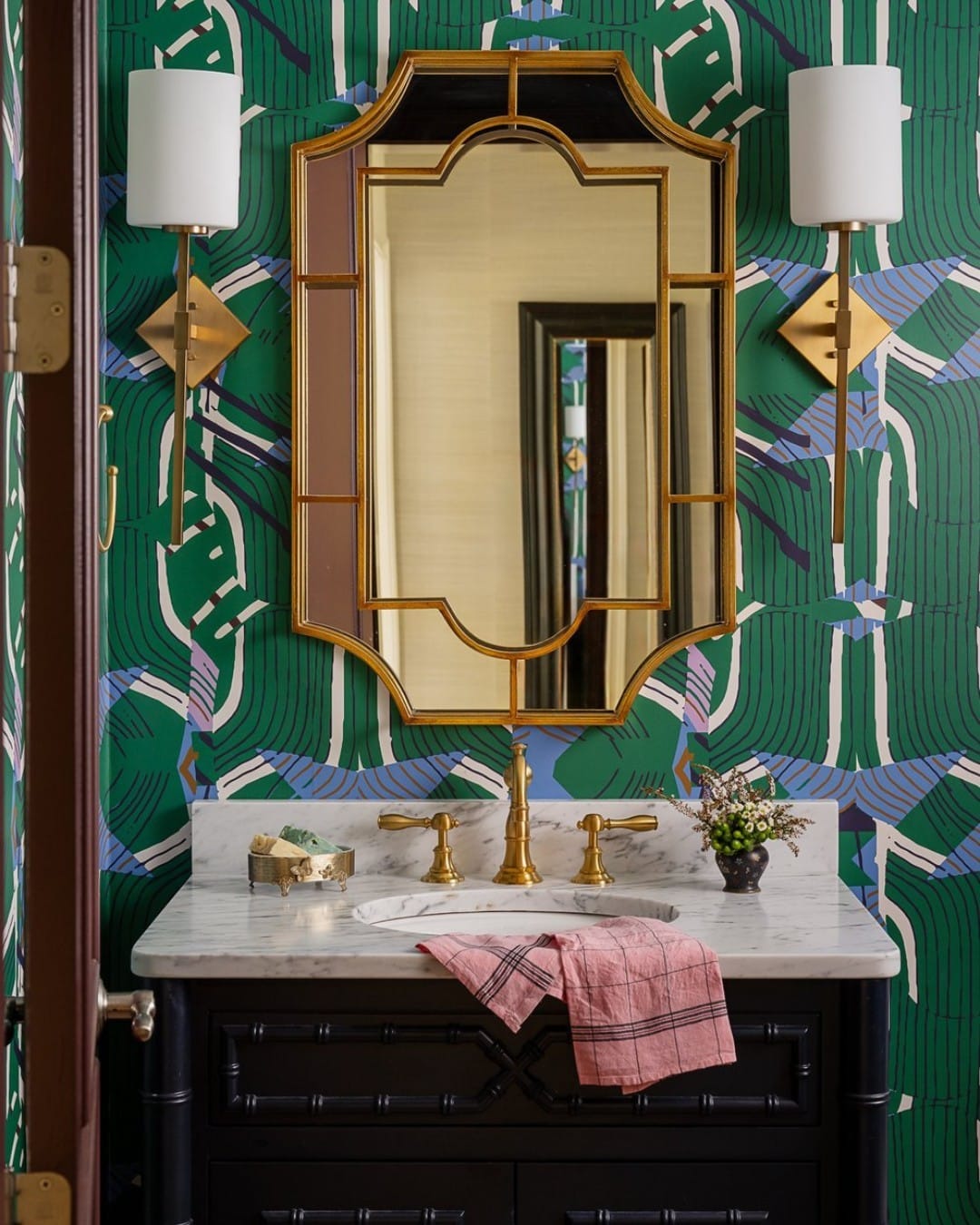 green glass soap dispenser on marble countertop